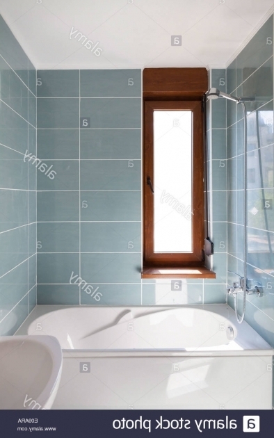 Image of Vertical Bathtub Vertical Shot Of Light Bathtub In A Bathroom With Window Stock